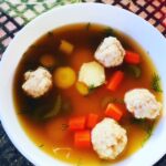 Bowl of matzo ball soup. You can see matzo balls, carrots, celery and dill, Vegan Matzo Ball Soup,